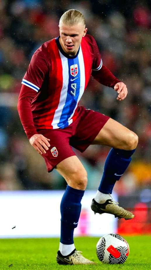 A soccer player in a red and blue kit with Norway’s flag is controlling a ball on the field during a match, an exciting moment you won’t want to miss—Purchase IPTV to catch all the live action.
