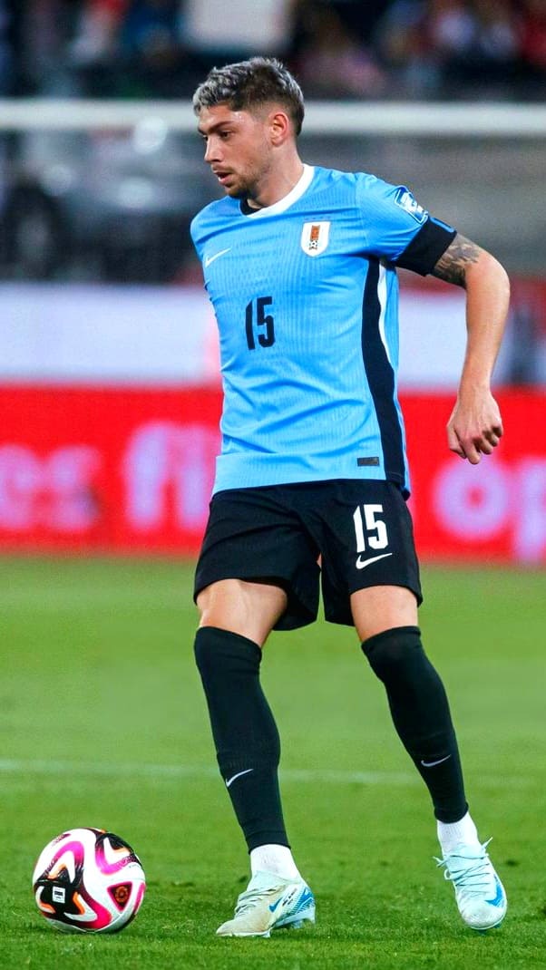 A soccer player wearing Uruguay’s light blue jersey with the number 15 controls a ball on the field during a match—action you won’t miss when you purchase IPTV for uninterrupted live coverage.