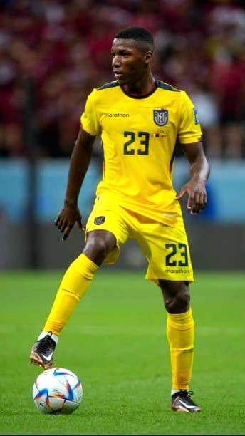 A soccer player in a yellow Ecuador uniform with number 23 controls the ball on the field during a match, an exciting moment you can catch when you purchase IPTV for live sports streaming.
